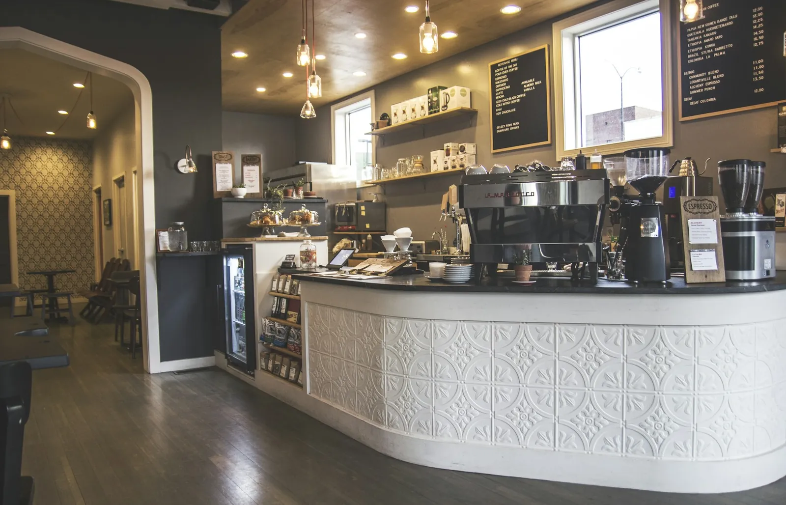 A café counter with espresso machines and a menu board