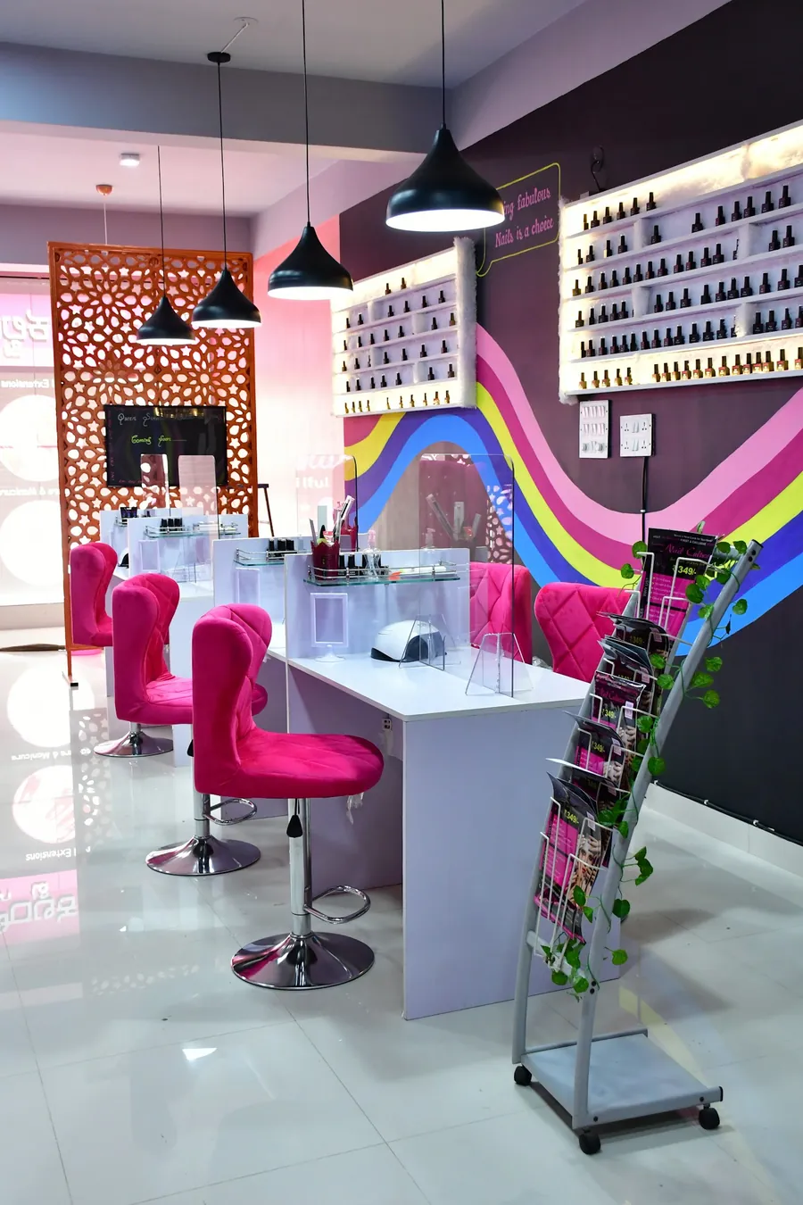 Manicure stations and a polish wall in a bright nail salon