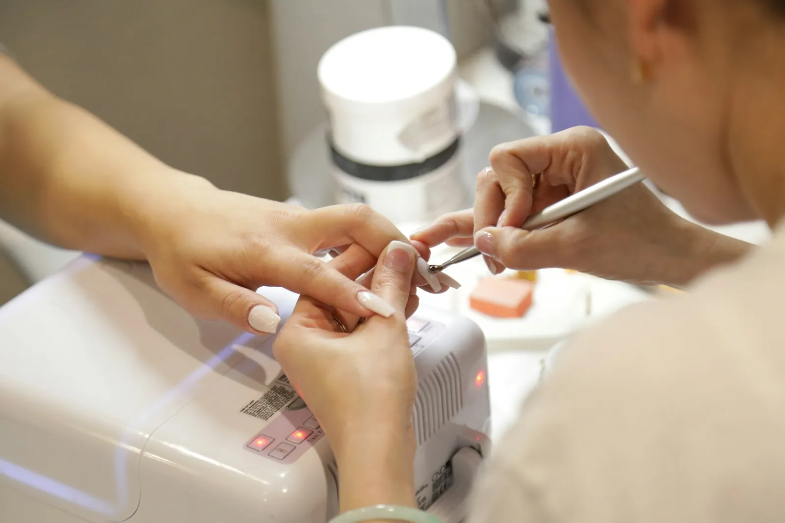 A nail technician working on a client's manicure