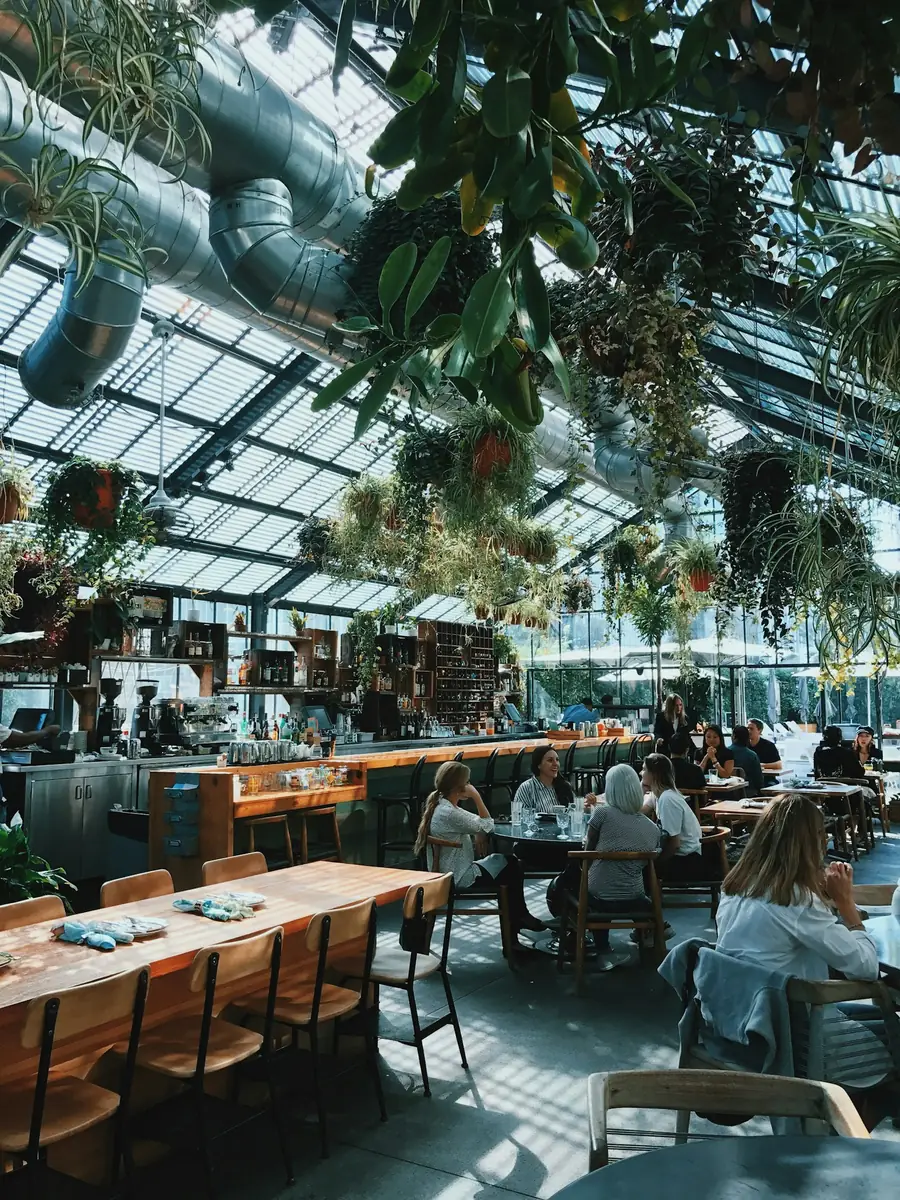 Guests dining in a bright, plant-filled restaurant