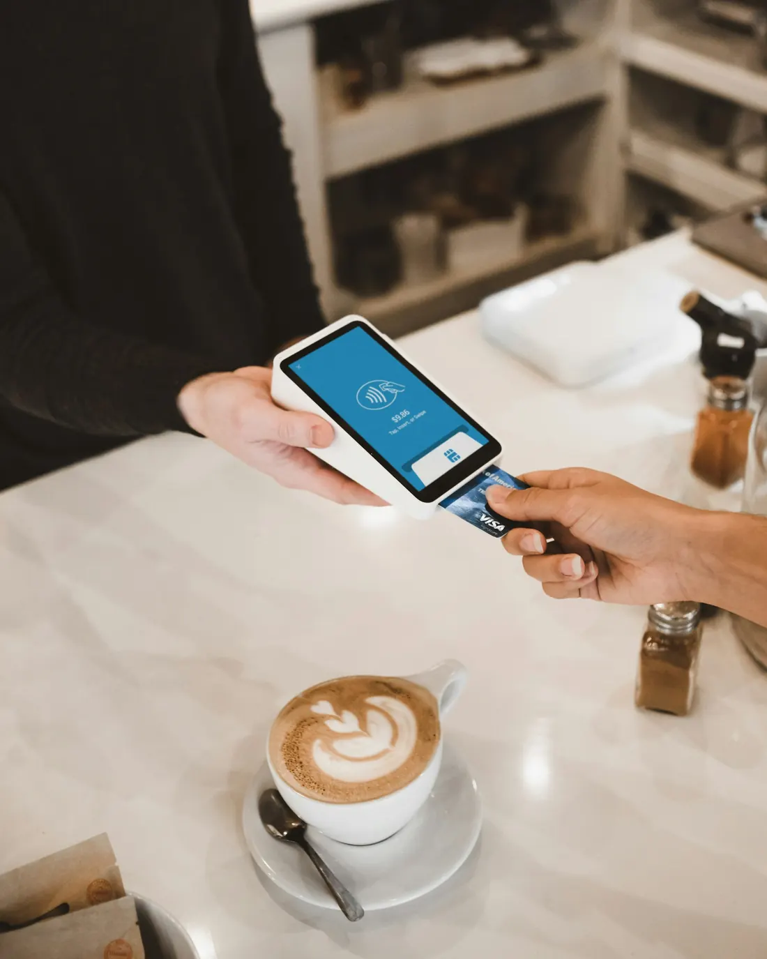 A customer paying by phone at a café counter